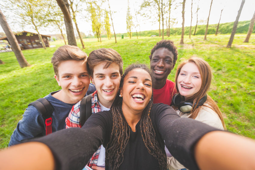 Group of multiethnic teenagers taking a selfie at park