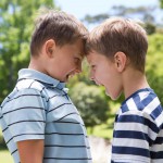 Sibling boys having a fight, bullying on a sunny day