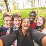 Group of multiethnic teenagers taking a selfie at park